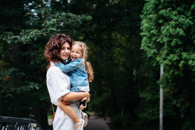 Belle jeune maman et sa fille en journée ensoleillée au parc, famille heureuse