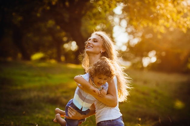 Belle jeune mère avec son fils s&#39;amuser dans un parc