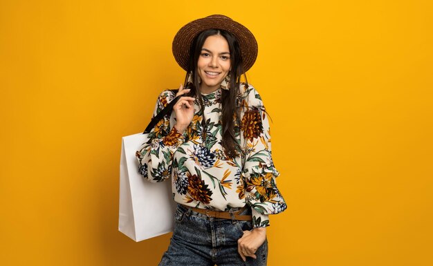 Belle jolie femme brune élégante tenant un sac à provisions blanc