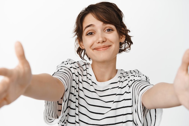 Belle Jolie Fille Brune Atteignant Un Câlin Recevoir Quelque Chose Dans Les Mains Tendues Ouvertes Et Souriant Tendrement Debout Sur Fond Blanc