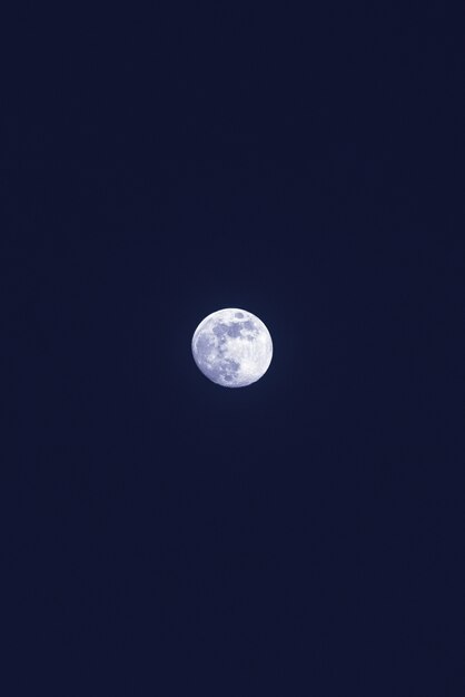 Belle lune blanche solitaire dans le ciel bleu foncé