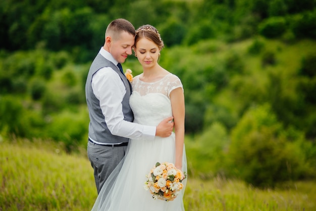 Belle mariée et élégant marié marchant après la cérémonie de mariage.