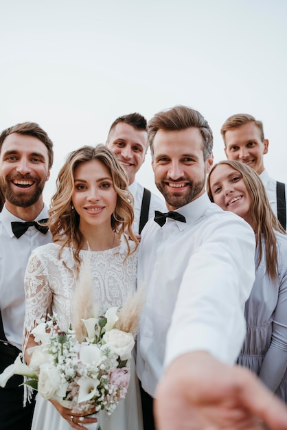 Photo gratuite belle mariée et le marié ayant leur mariage avec des invités sur une plage