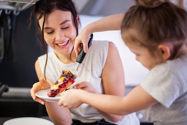 Belle mère et jeune fille partageant un gâteau