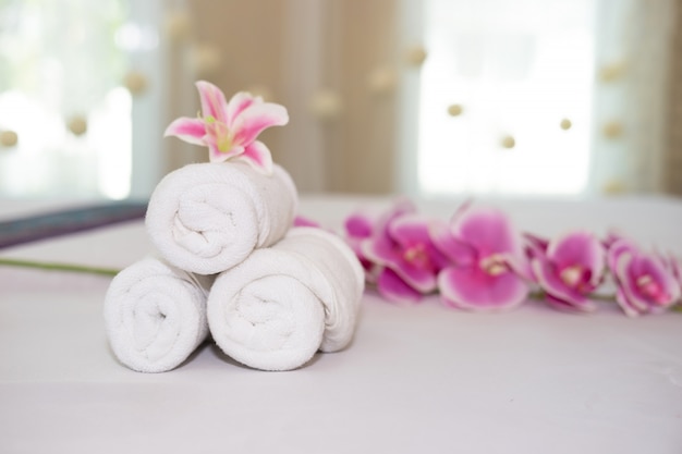 belle orchidée rose sur une serviette blanche dans un salon spa.