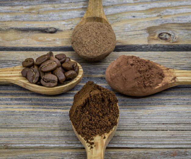 Une belle petite cuillère en bois avec du café sur l'angle différent du bois, gros plan