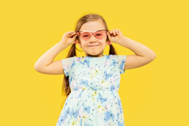 Belle petite fille émotionnelle isolée sur jaune