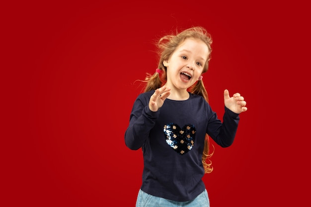 Belle petite fille émotionnelle isolée sur rouge