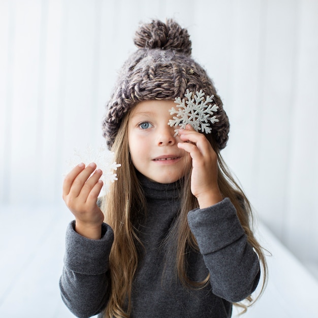 Belle petite fille tenant des flocons de neige