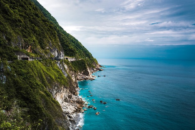 Belle photo aérienne de falaises boisées près d'un océan bleu clair