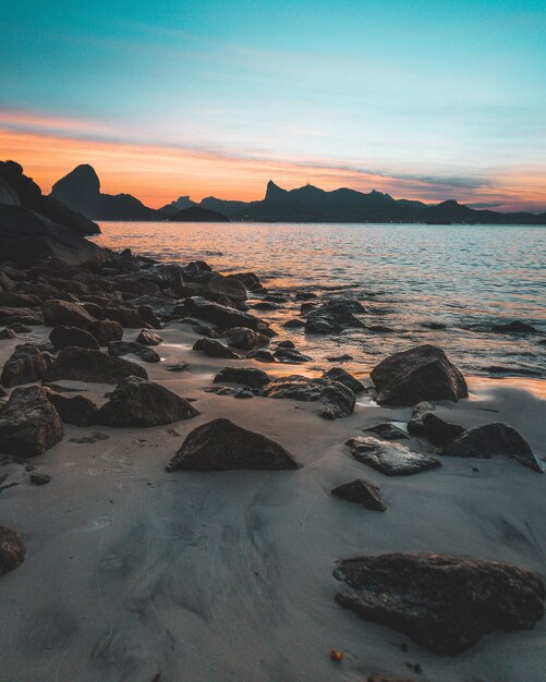 Belle photo de la côte rocheuse de la mer au coucher du soleil avec un ciel bleu incroyable