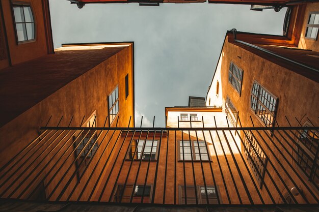 Belle photo de dessous de bâtiments orange et d'une clôture devant