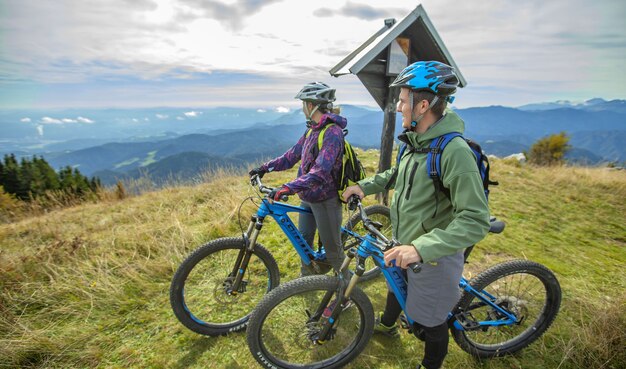 Belle photo de deux cyclistes debout et regardant les merveilles de la nature