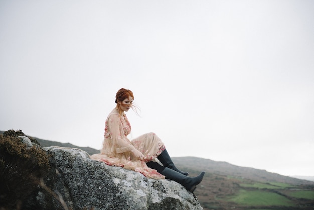 Belle photo d'une femme au gingembre avec une peau d'un blanc pur dans une robe rose