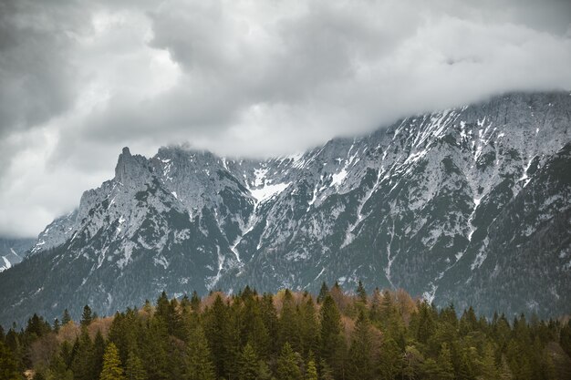 Belle photo d'une haute montagne recouverte d'épais nuages blancs