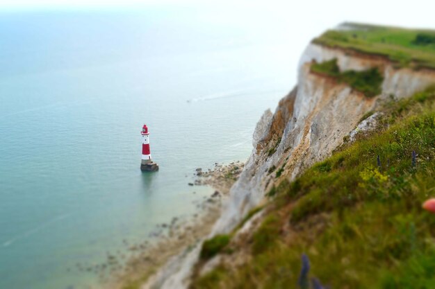 Belle photo d'un phare dans l'océan calme près de la falaise