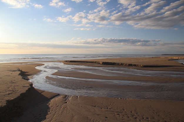 Belle photo d'une plage sous un ciel bleu nuageux