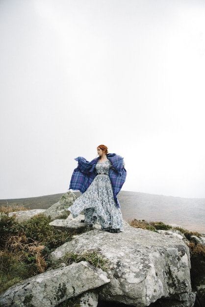 Belle photo verticale d'une femme au gingembre avec une peau d'un blanc pur dans une jolie robe légère