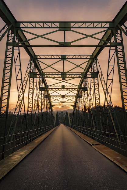 Belle photo verticale d'un pont au coucher du soleil