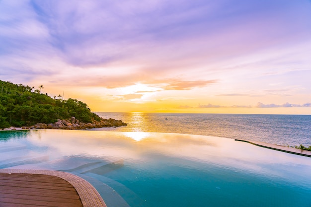 Photo gratuite belle piscine à débordement extérieure dans un complexe hôtelier avec vue sur la mer, océan et nuage blanc, ciel bleu