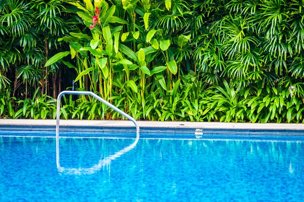 Belle piscine extérieure avec chaise et parapluie pour les voyages et les vacances.