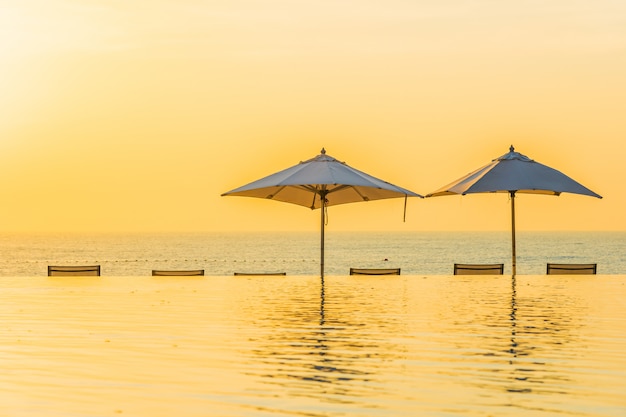 Belle piscine en plein air avec parasol et chaise longue dans le complexe hôtelier pour se détendre