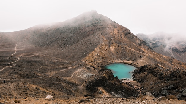 Belle Prise De Vue Aérienne D'un Petit Lac Au Milieu Du Désert Près D'une Montagne Un Jour Brumeux