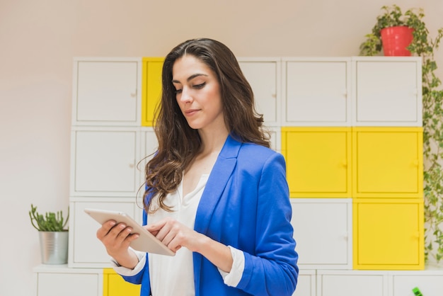 Belle vérifiant sa tablette dans le bureau employé