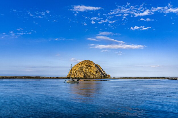 Belle vue sur un bateau près d'une île au milieu de l'océan sous le ciel bleu