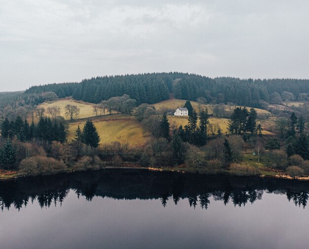 Belle vue sur une maison à proximité d'un lac entouré d'arbres dans une forêt