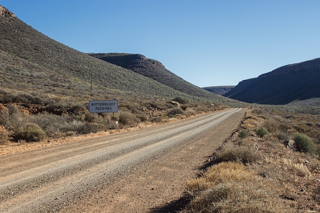 Belle vue sur une route entourée de collines par une journée ensoleillée