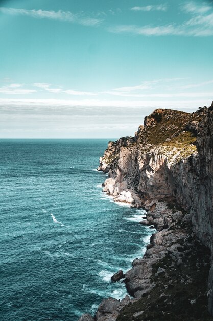 Belle vue verticale du bord de mer rocheux et de la mer calme bleue