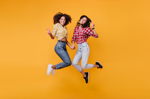 De belles brunes montrent des signes de paix. Des filles de bonne humeur posent