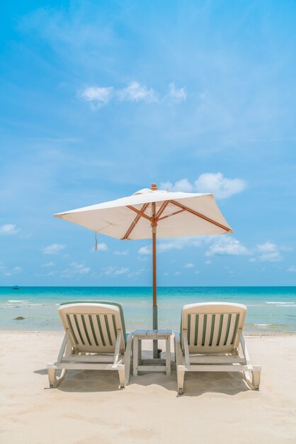 Belles chaises de plage avec parasol sur tropical sable blanc beac