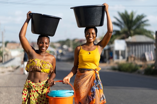 Belles femmes africaines allant chercher de l'eau à l'extérieur