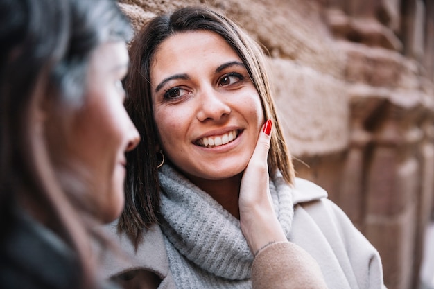 Belles femmes aimantes caressant sur la rue