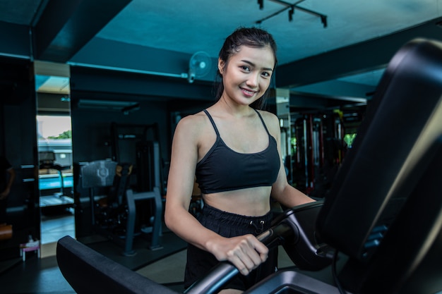 De belles femmes en forme physique se préparent à courir sur le tapis de course dans le gymnase.