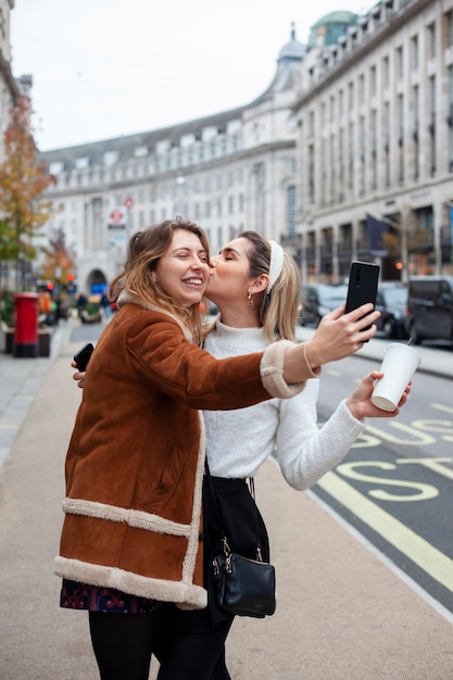 Photo gratuite belles femmes lesbiennes s'embrassant à l'extérieur