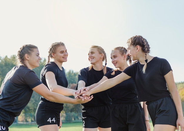 Belles filles sportives mettant les mains ensemble