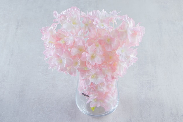 Belles fleurs fraîches de parfum dans une cruche, sur la table blanche