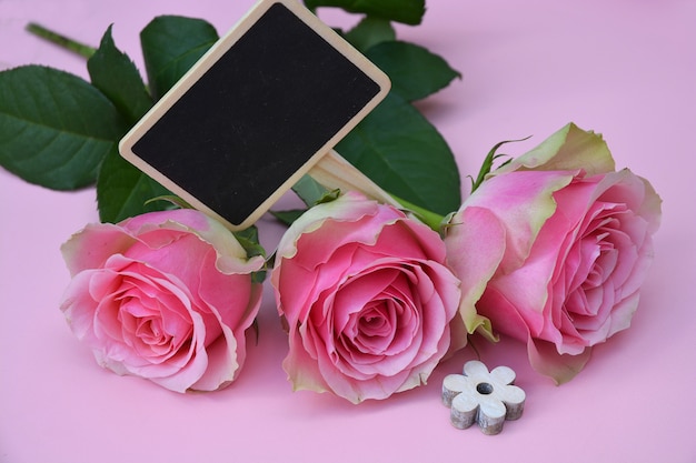 Photo gratuite belles fleurs roses avec une fleur en forme de bois sur une surface rose