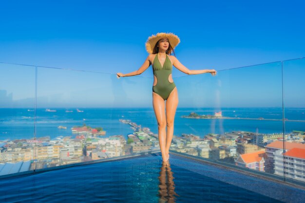 Belles jeunes femmes asiatiques sourire heureux se détendre autour de la piscine extérieure de l'hôtel pour voyager en vacances