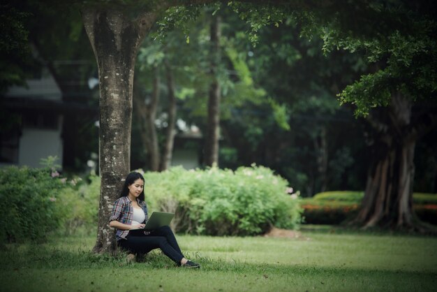 Belles jeunes femmes lisant un livre dans le parc en plein air