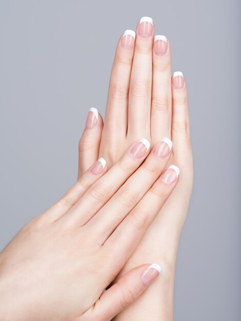 Belles mains féminines avec manucure française sur les ongles