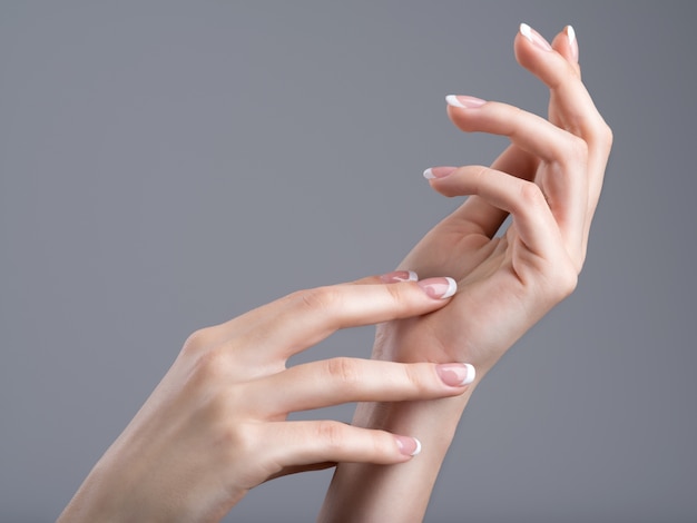 Belles mains féminines avec manucure française sur les ongles