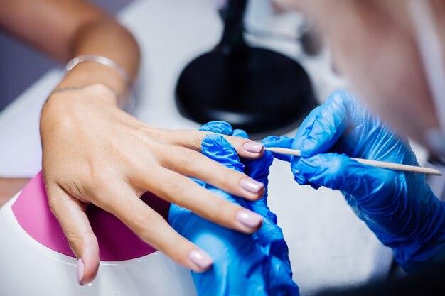 Belles mains féminines Traitement des ongles des doigts processus de fabrication Foreuse à ongles professionnelle en action Concept de soins de beauté et des mains