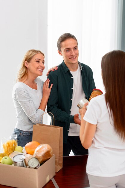 Bénévoles posant avec receveur de dons alimentaires