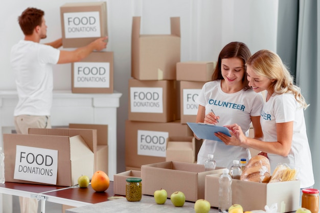 Des bénévoles préparent des boîtes avec de la nourriture pour la charité