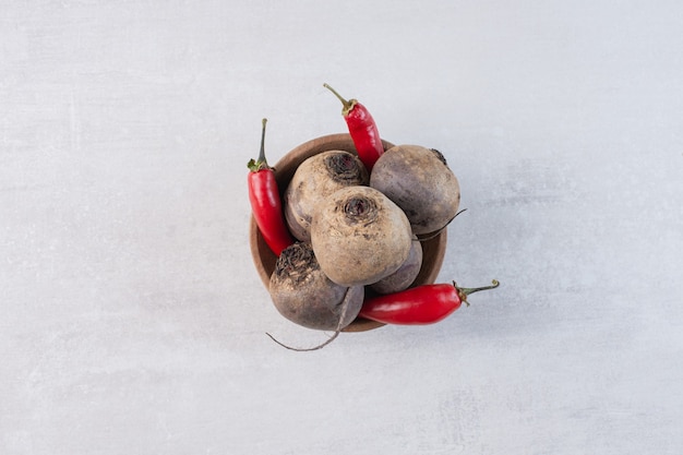 Photo gratuite betteraves crues et piments dans un bol en bois. photo de haute qualité