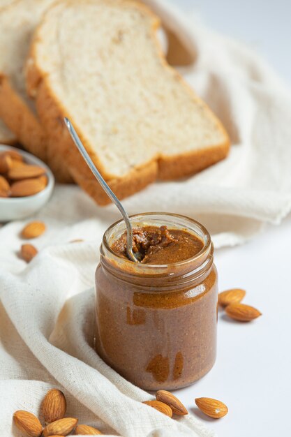 Beurre d'amandes biologiques crus sur fond blanc